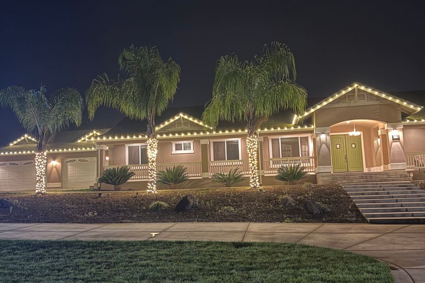 Christmas light installation in Cameron Park, CA: ranch home warm white roofline palm wraps front
